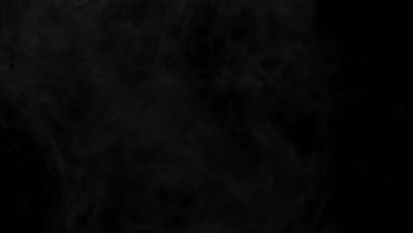Milk pouring into liquid against a black background,