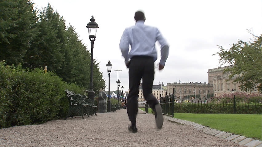 A businessman jumping in a park