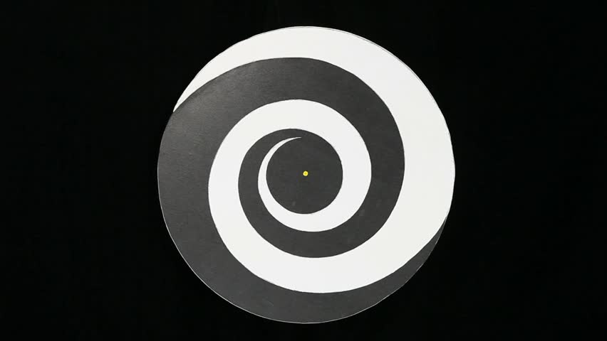Spinning black and white hypnotizing wheel.  Wide shot.  