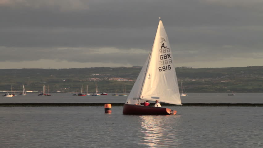 WIRRAL, CHESHIRE/ENGLAND - MAY 16: Unidentified sail boat and crew gybe on the Marine Lake  on May 16, 2012 in West Kirby. The Marine Lake is a man made coastal lake fed by the sea at high tide.