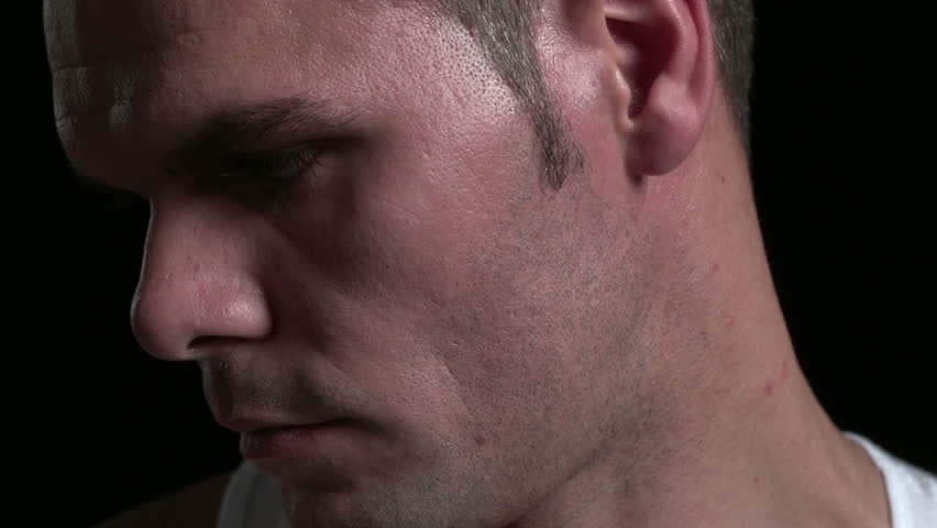 Serious man, looking up, black background