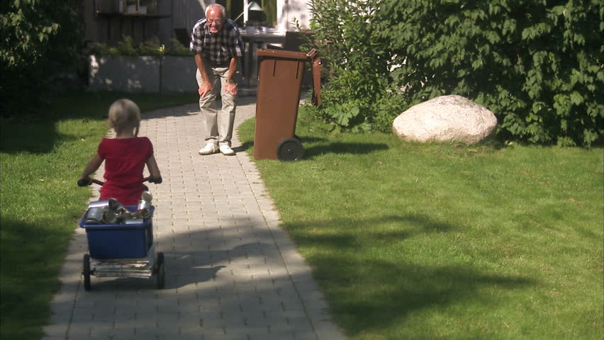 Granddaughter and grandfather recycling cans