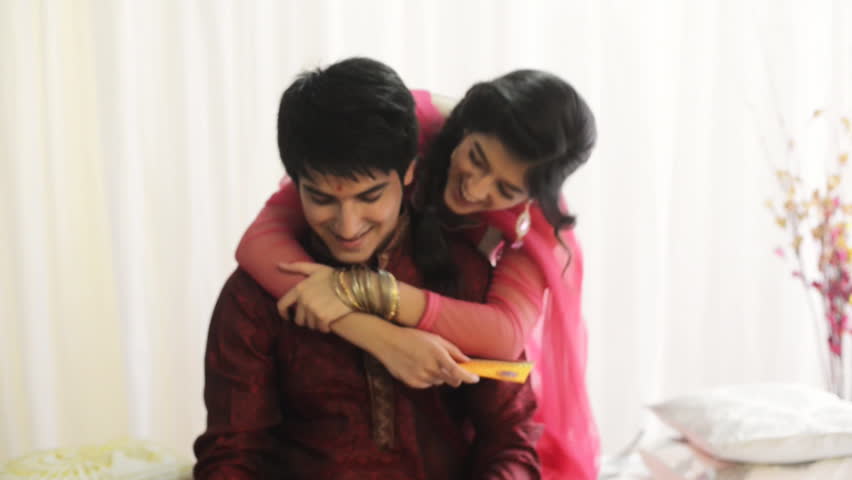 Zoom in shot of a teenage girl hugging her brother from behind