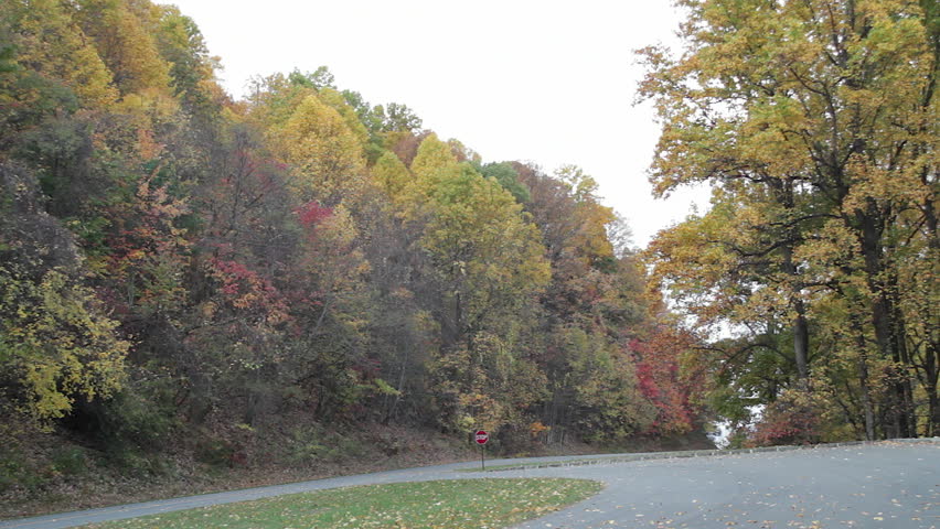 A car and a group of motorcycles drive on the Blue Ridge Parkway, a famous mountain highway in Virginia and North Carolina.