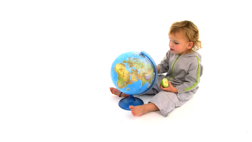 Cute little blonde boy plays with world globe