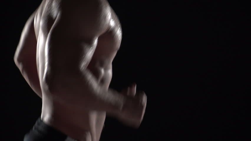 Muscular man running in profile, close up torso