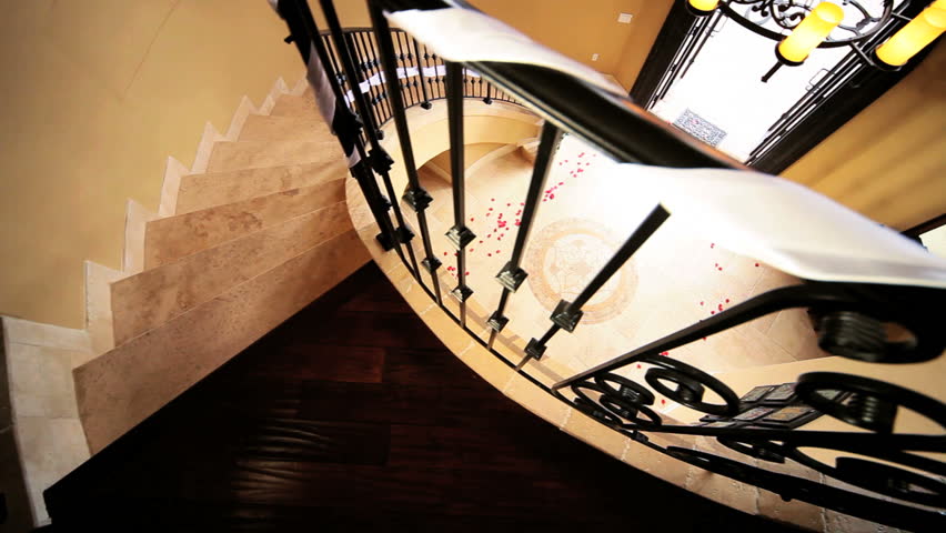 Young bride in full wedding dress veil running out elegant entrance hall luxury house