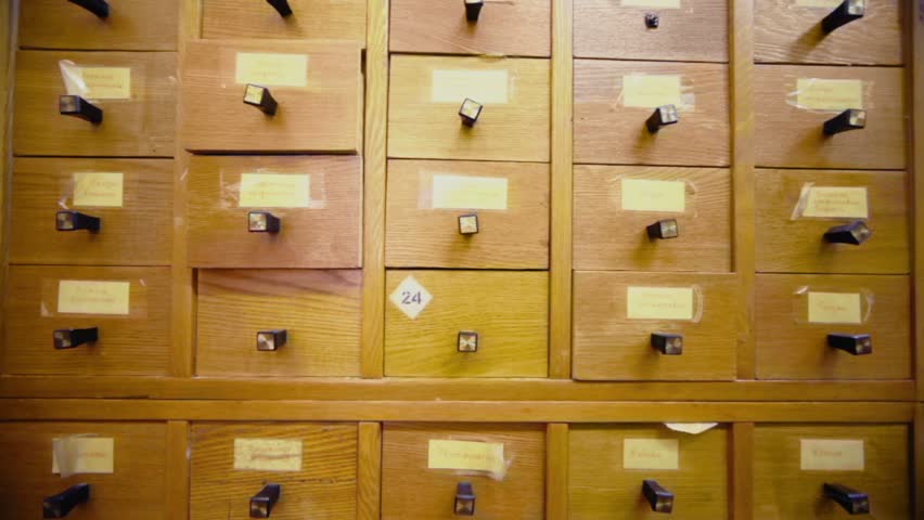 Hand opens box in cabinet and takes something, then close