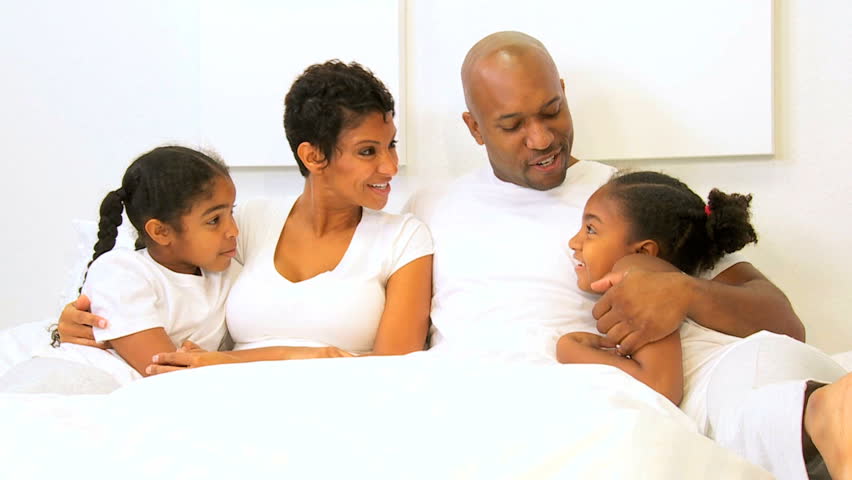 African American family sharing time bedroom home weekend