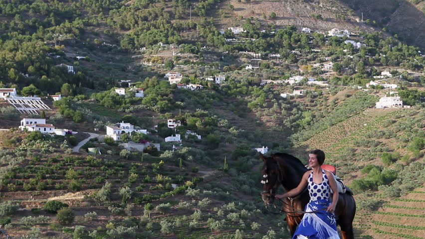 Woman standing on a hill in Andalusia with her horse