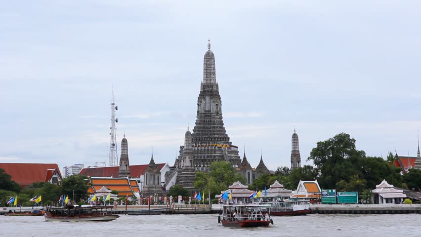 view of Wat Arun across Chao Phraya River during sunset in Bangkok, Thailand 