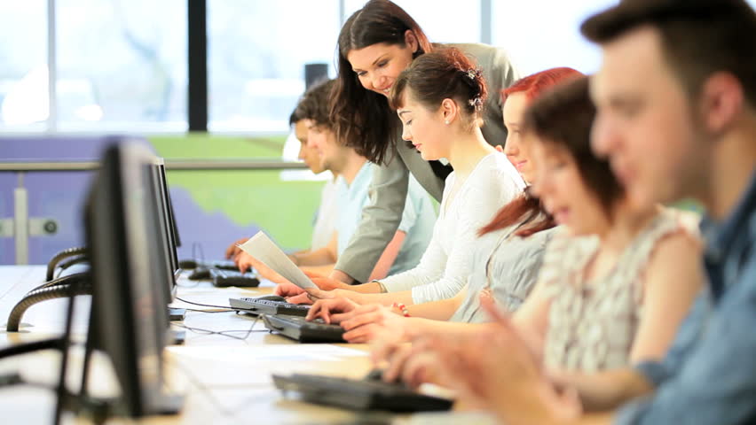 Female brunette lecturer learning multi ethnic students in modern university technology class