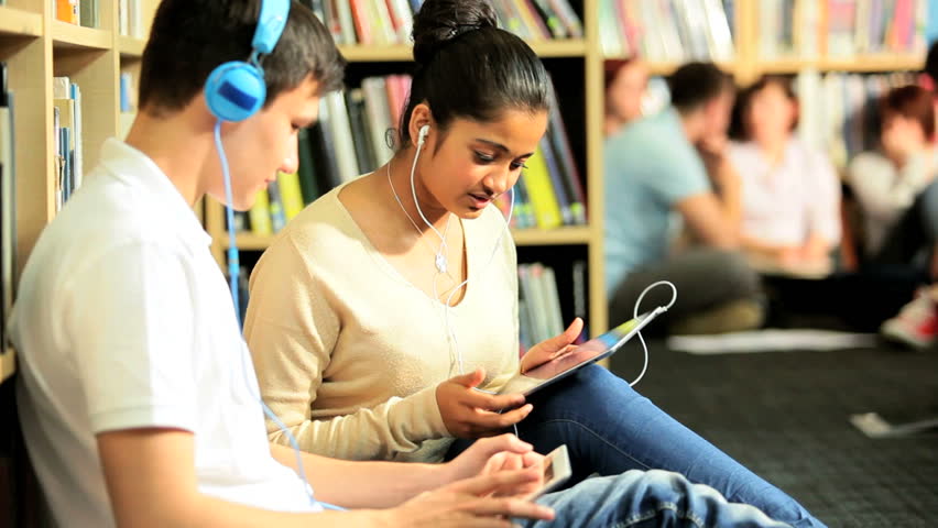 Young multi ethnic students study and listening to mp3 player in university hub