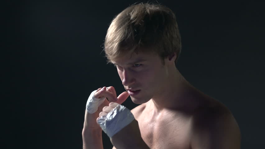 Man shadow boxing, black background