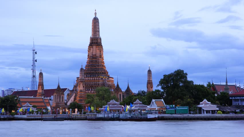 Twilight view of Wat Arun across Chao Phraya River during sunset in Bangkok, Thailand