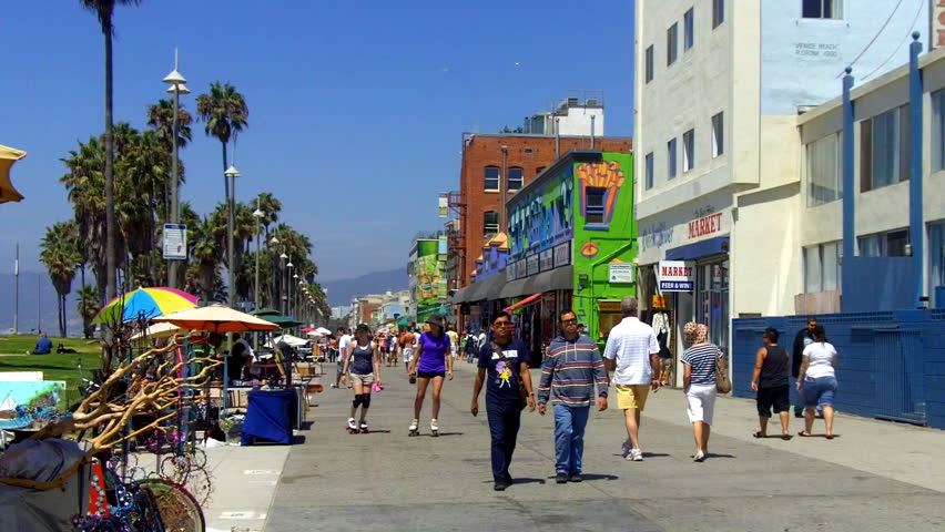 VENICE BEACH, CA - August 2, 2012:  Tourists walk and roller skate past merchant shops and stands on the Venice Beach Boardwalk circa 2012 in Venice Beach.