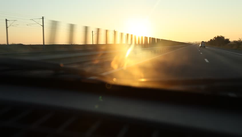 Can runs on highway at sunrise and passes under bridges or crossroads. Dramatic sun and clouds look.

