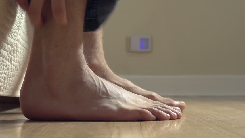 Close up, feet getting out of bed, hitting floor