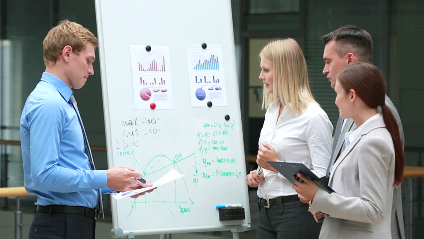 Group of business workers solving financial problems with the use of graphs and coefficients
