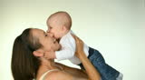 happy mother kissing her adorable baby in studio