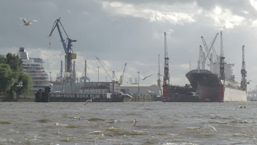 HAMBURG - JUNE 3, 2012: Cargo ship mooring at the Hamburg port. Flying gulls.
