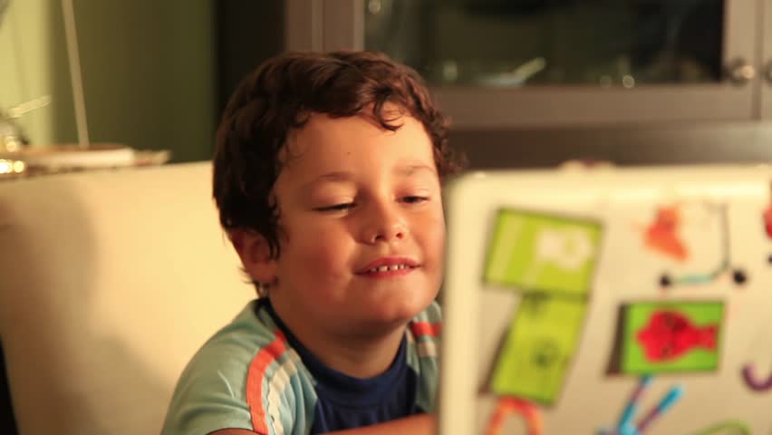 little boy watching notebook and smiling