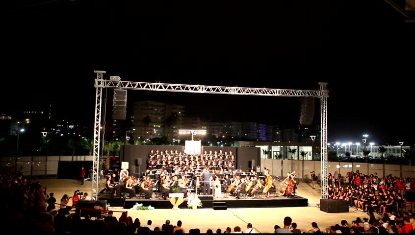 MERSIN - OCTOBER 3: Members of the Mersin State Opera and Ballet Orchestra and Choir perform the Opening Concert live at Mersin Marina open air stage on October 3 2012 in Mersin, Turkey.