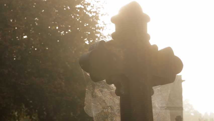 Pan to cross in churchyard