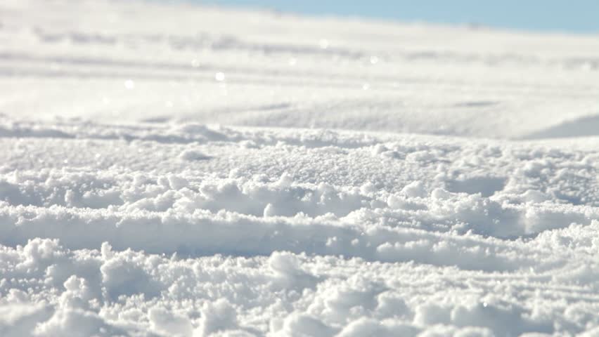 Close up of man in boots walking through crisp snow.