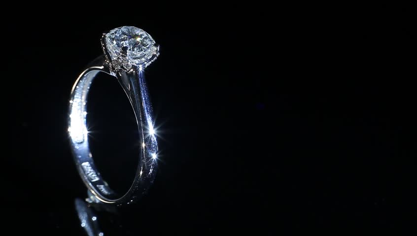 Silver diamond excellent ring with turning on themselves against a black background 