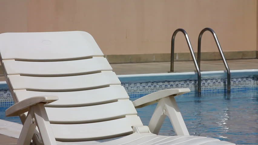 empty sunbed at swimming pool