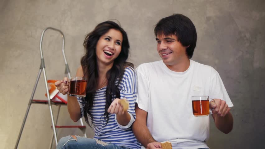 Attractive couple taking a tea andd biscuit break after remodling