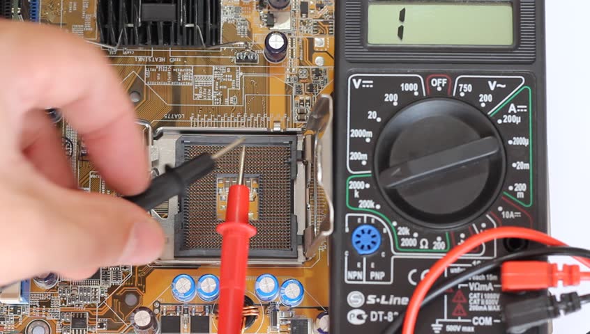 Man measures digital multimeter motherboard and processor.