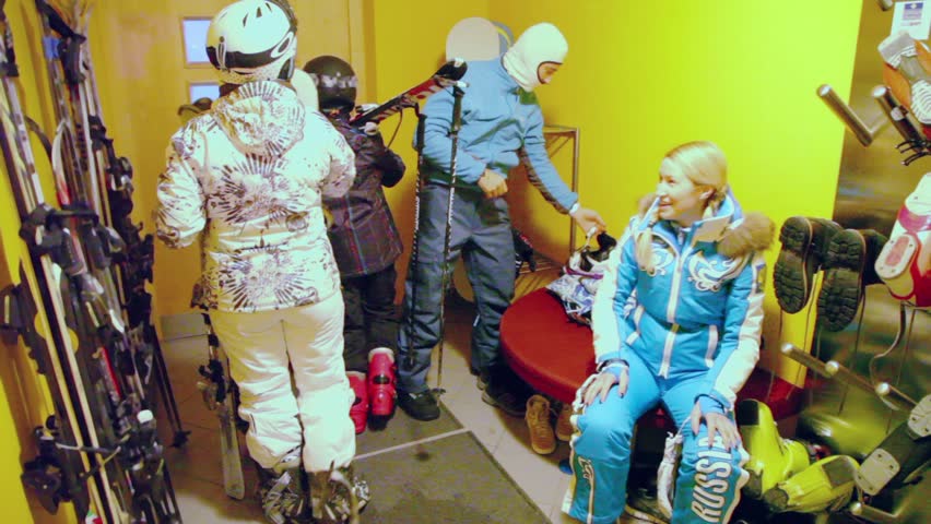 Four riders prepares to ride skiing small room with lot of equipment