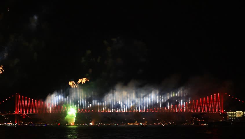 Colorful fireworks all over the Istanbul sky. View of Bosporus Bridge. Pan from cable bridge to the Besiktas region. 