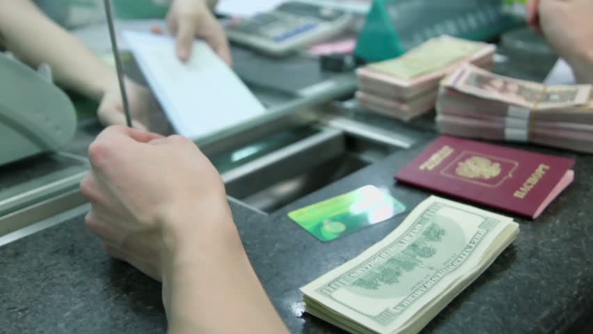Man puts his signature on documents for exchange in bank