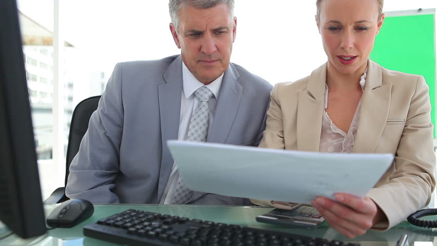 Businessman discussing a document with his colleague in an office