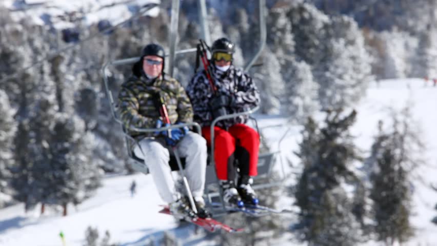 SOELDEN - FEB 16: Two skiers rise in chairlift over valley to mountain top to ski, on Feb 15, 2012 in Soelden, Austria