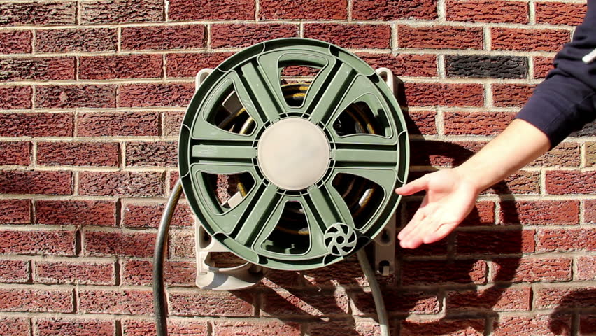 Winding-up a household garden hose. 