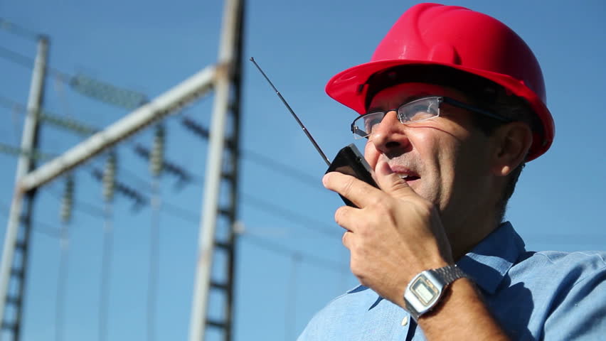 Power Lines and Engineer.
Electrical engineer talking over telecommunication equipment beside electrical substation. Rack focus. HD1080p.