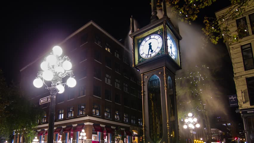 VANCOUVER - CIRCA OCTOBER 2012: Time lapse wide shot of the Stream Clock with Harbour Center in the cackground circa October 2012. One of the tourist attractions in Vancouver, Canada