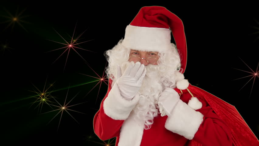 Santa Claus carrying his bag, is looking at the camera and sends a kiss with golden stars