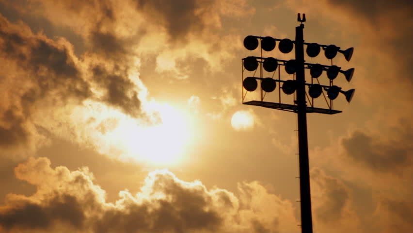 Sun setting behind a cloudscape and a silhouetted stadium light, part 2