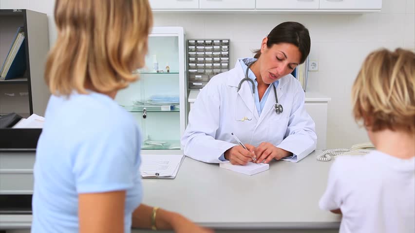 Doctor giving a prescription to a patient in her medical office
