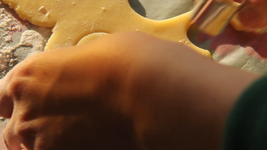 Baking Sugar Cookies 13. Preparing, mixing, baking and decorating Christmas sugar cookies. Making a gingerbread man shaped cookie using a cookie cutter.