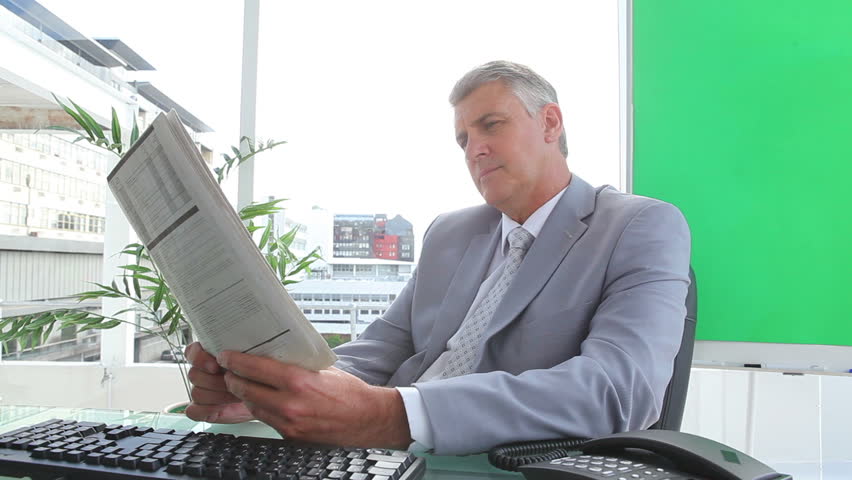 Businessman reading a newspaper in an office