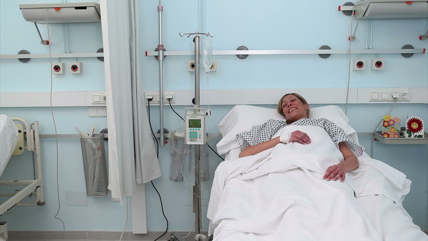 Doctor assisting a patient in a wheelchair in hospital ward