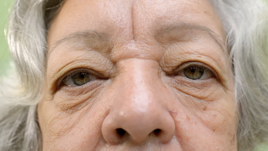 Elderly people and feelings, details of face and eyes of senior woman with white hair looking at camera. Sequence