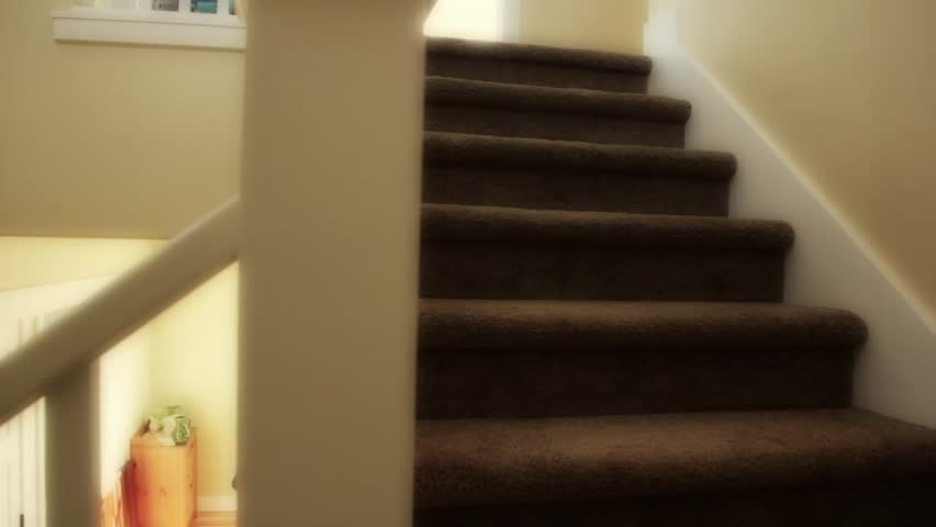 A dolly shot of carpeted stairs in a new home