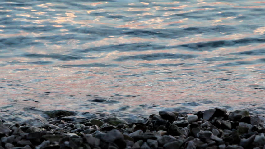 Blue waves at dusk

Description: Sea water with a reflection on the pebble beach.

